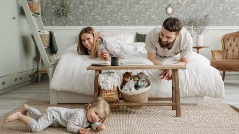 A joyful family bonding in a cozy bedroom, featuring a playful child and loving parents.