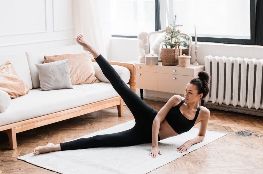 A woman exercises, performing yoga in a stylish living room with soft natural lighting.